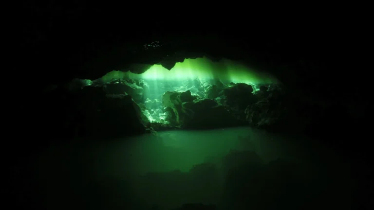 מראה מיסטי שנוצר כאשר קרן שמש חודרת למערה ומאירה את השכבות העליונות של המים הצלולים.