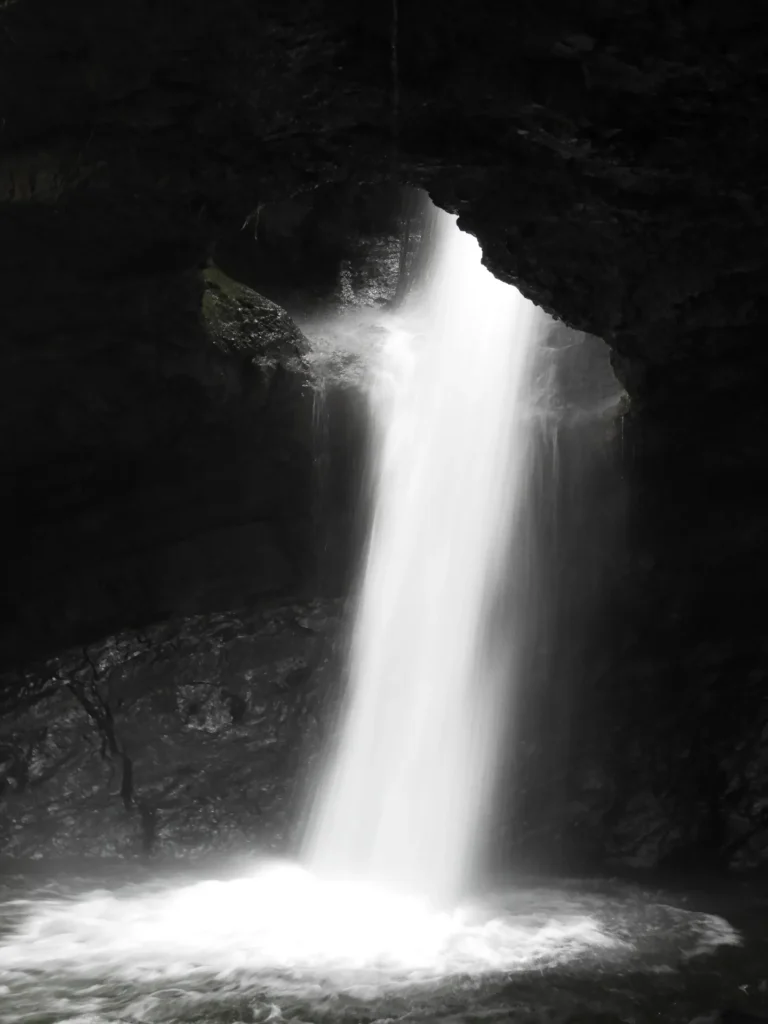 מפל המים זורם דרך פתח בתקרת המערה